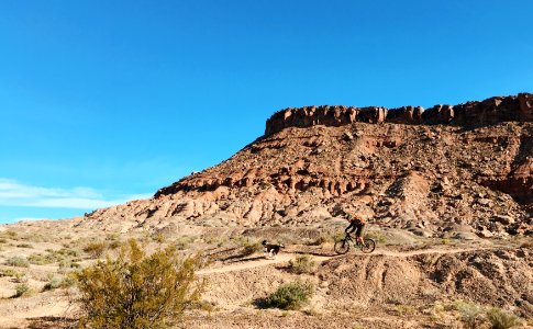 person riding bicycle near brown rock formation during daytime photo