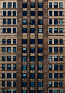 brown concrete building with blue glass windows during daytime photo