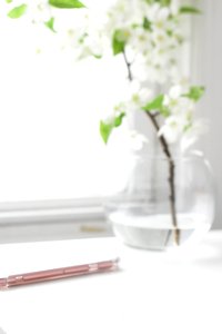 white flowers in clear glass vase on white table photo