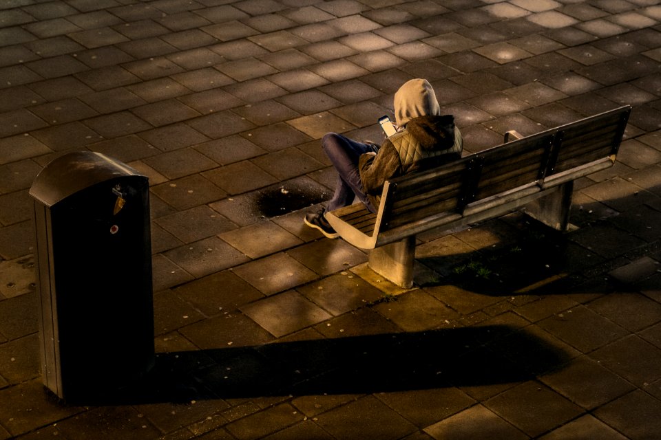 person sitting on outdoor bench during daytime