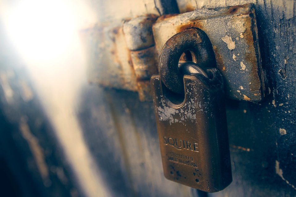 brown padlock in black wooden door