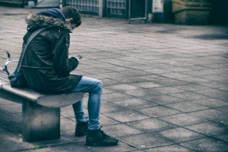 man sitting on bench holding phone