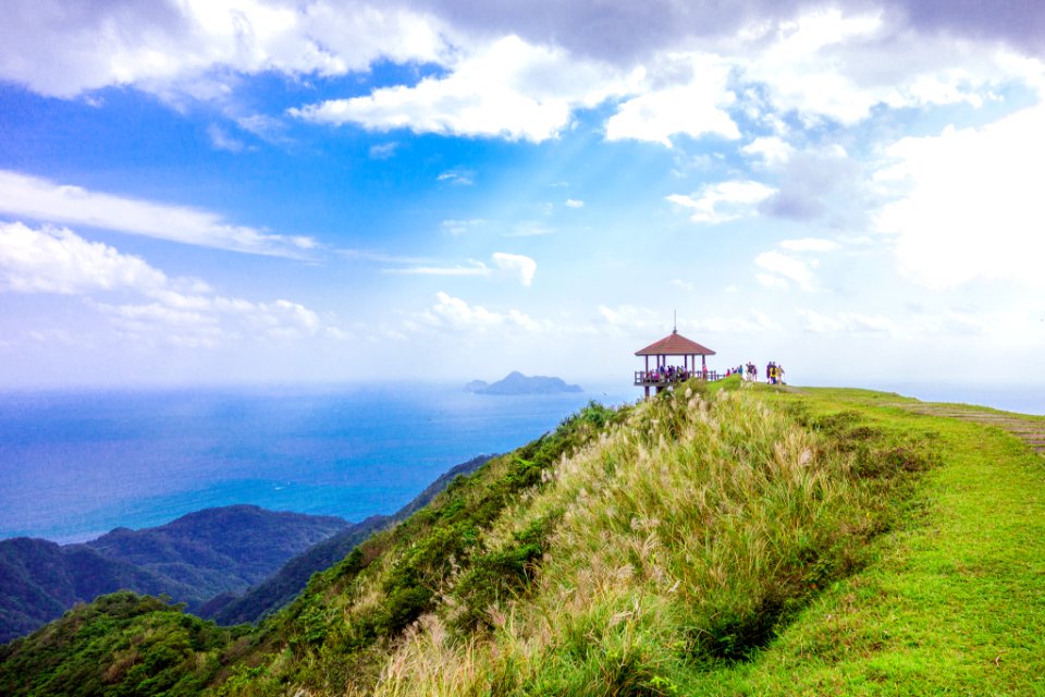 brown gazebo on top of green mountain overlooking sea during daytime landscape photography