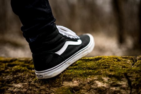person wearing black and white Vans Sk8-Hi photo