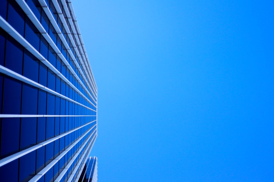 low-angle photography of curtain glass building under blue sky photo