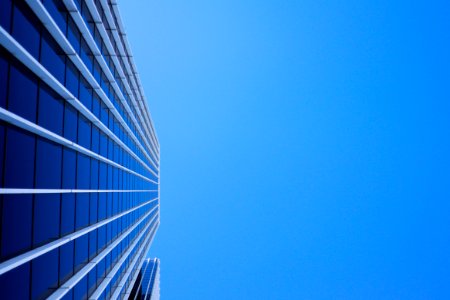 low-angle photography of curtain glass building under blue sky photo