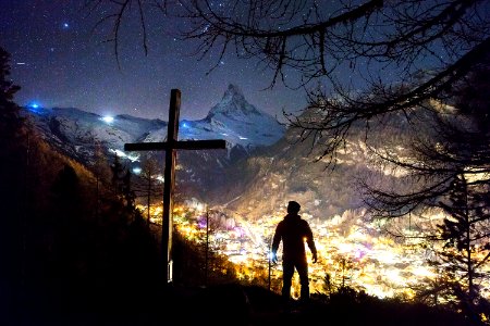man standing near cross during night photo