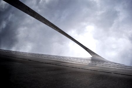 greyscale low-angle photography of arc gate under cloudy sky photo