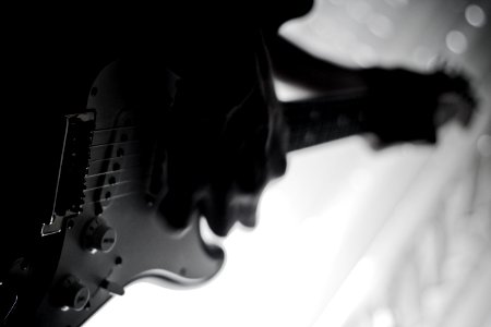 grayscale photo of person playing electric guitar