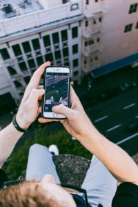 man taking photo above building photo