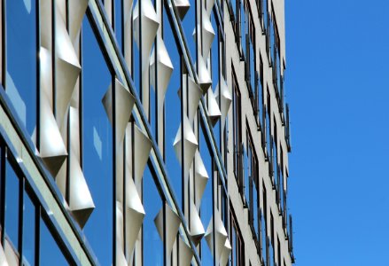 low-angle photography of curtain wall building under blue sky at daytime photo