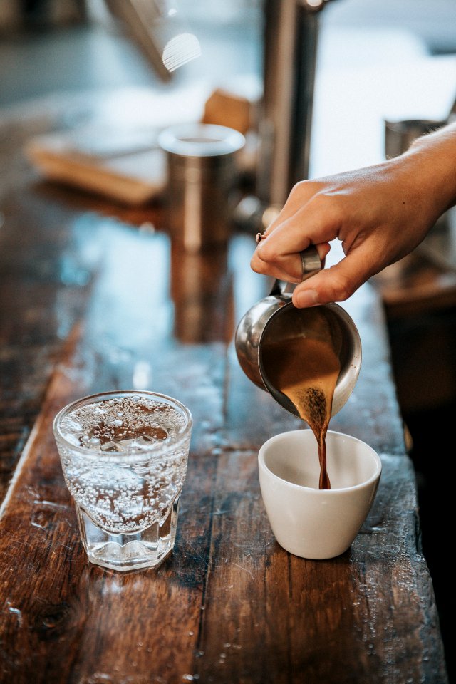 person pouring coffee in mug
