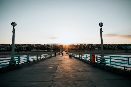 photography of person walking on bridge during daytime photo