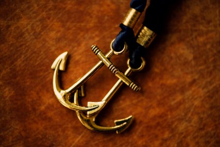 two gold-colored anchor pendants photo