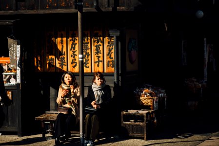 two women sitting on bench outdoor during daytime photo