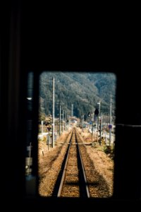 shallow focus photography of train rail near utility poles during daytime photo