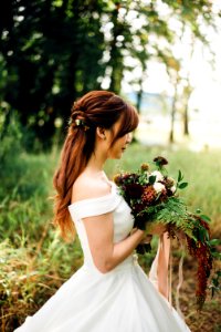 woman wearing white off-shoulder wedding gown wearing white petaled flower photo
