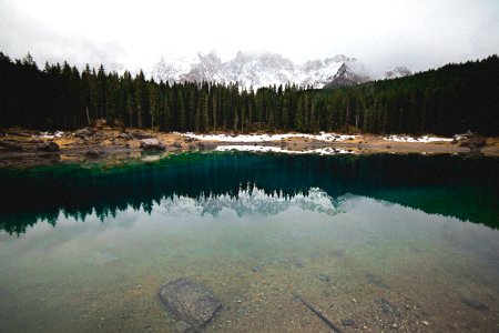 lake in forest near snow mountain