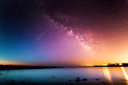 milky way above body of water photo