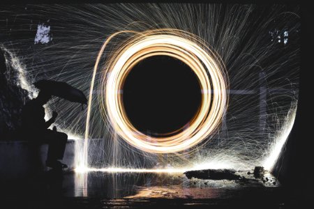 photo of person holding umbrella near steelwool during nighttime photo