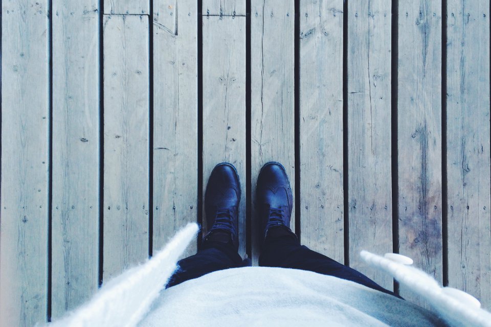 person standing on gray wooden floor photo