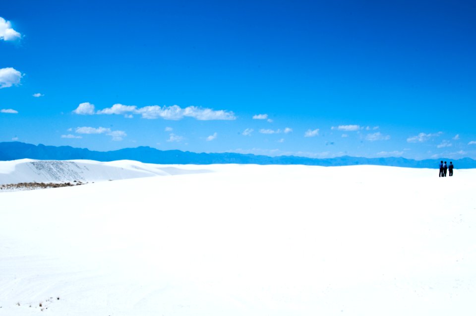 three person standing on snowfield