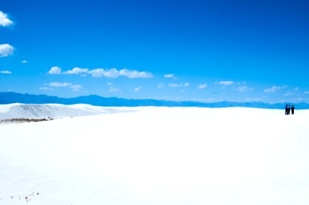 three person standing on snowfield photo