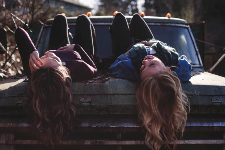 two women lying down on vehicle photo