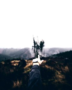 person's left hand pointing to castle
