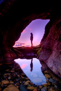 man standing in front of cave photo