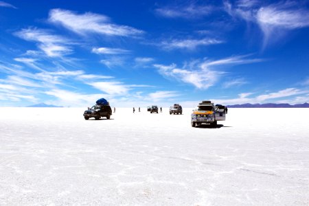 sports utility vehicles on desert under cloudy blue sky during daytime