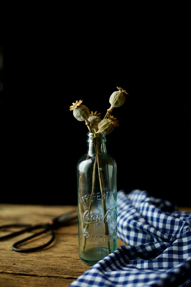 clear glass bottle with white flowers on table