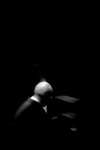 grayscale photo of man sitting on chair photo