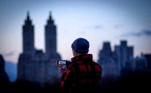 person taking a picture of city at daytime