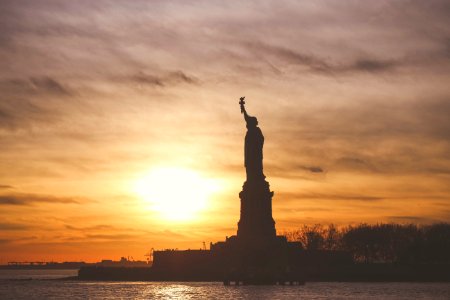 silhouette photo of Statue of Liberty during golden hour
