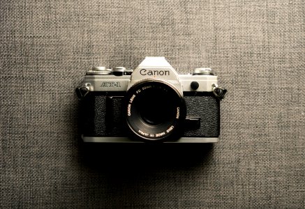black and gray Canon camera on gray textile photo