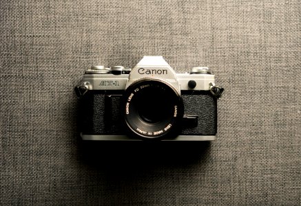 black and gray Canon camera on gray textile