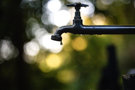 tilt shift lens photography of black steel faucet photo