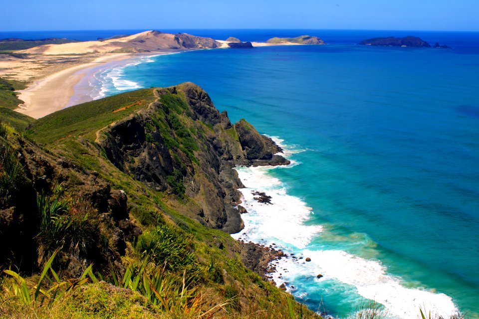 hills in front of sea during daytime