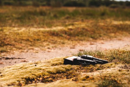 black revolver pistol on ground during daytime photo