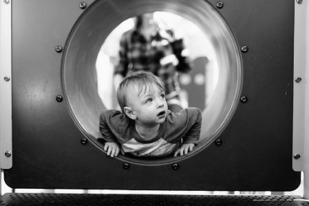 grayscale photo of child in hole