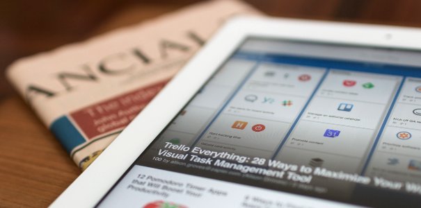 white tablet computer on top of newspaper photo