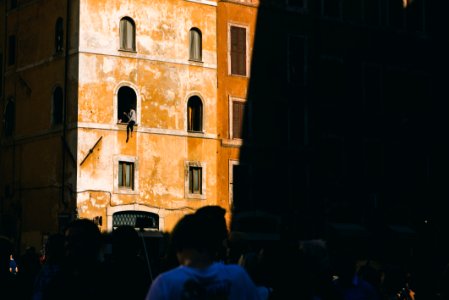 person sitting on building window photo