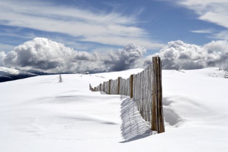 brown wooden fence on snow field under gray clouds photo