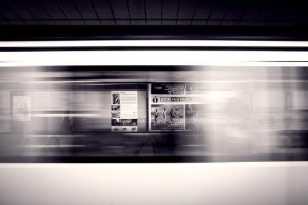 A long-exposure shot of a moving subway train and advertisement posters at the station photo
