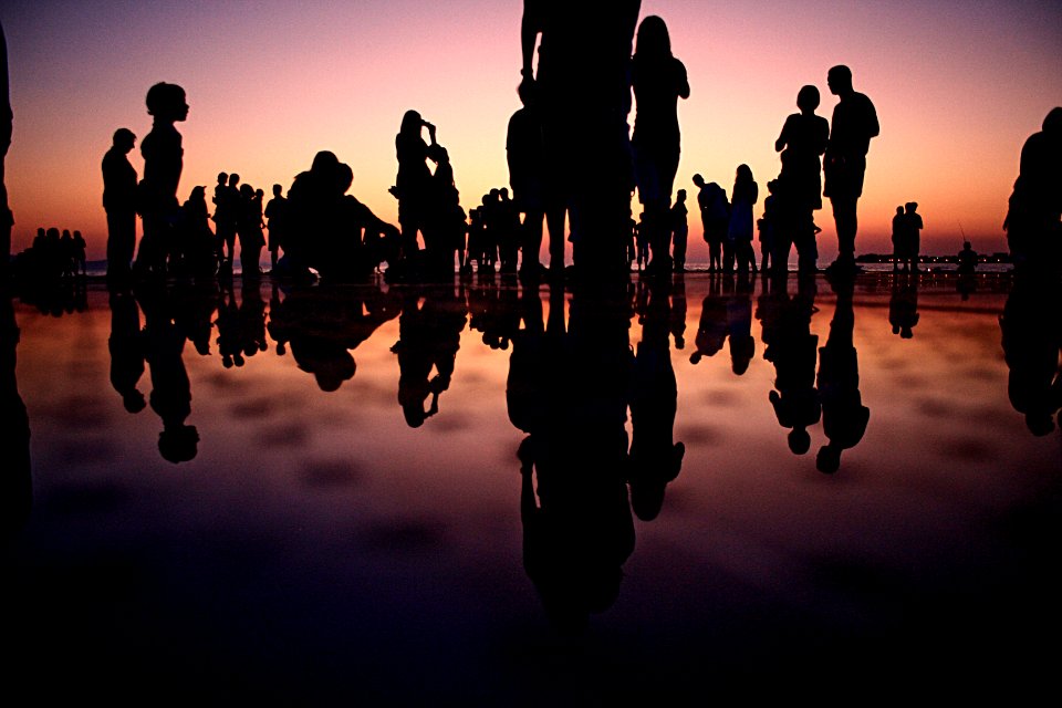 silhouette of people standing on mirror during golden hour
