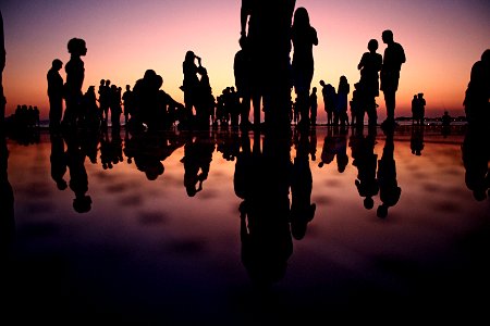 silhouette of people standing on mirror during golden hour photo