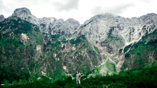 man standing near mountains surrounded with trees photo