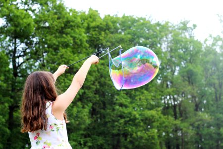 girl making bubbles during daytime photo
