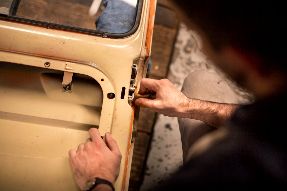 A man adjusting the lock mechanism on a car door